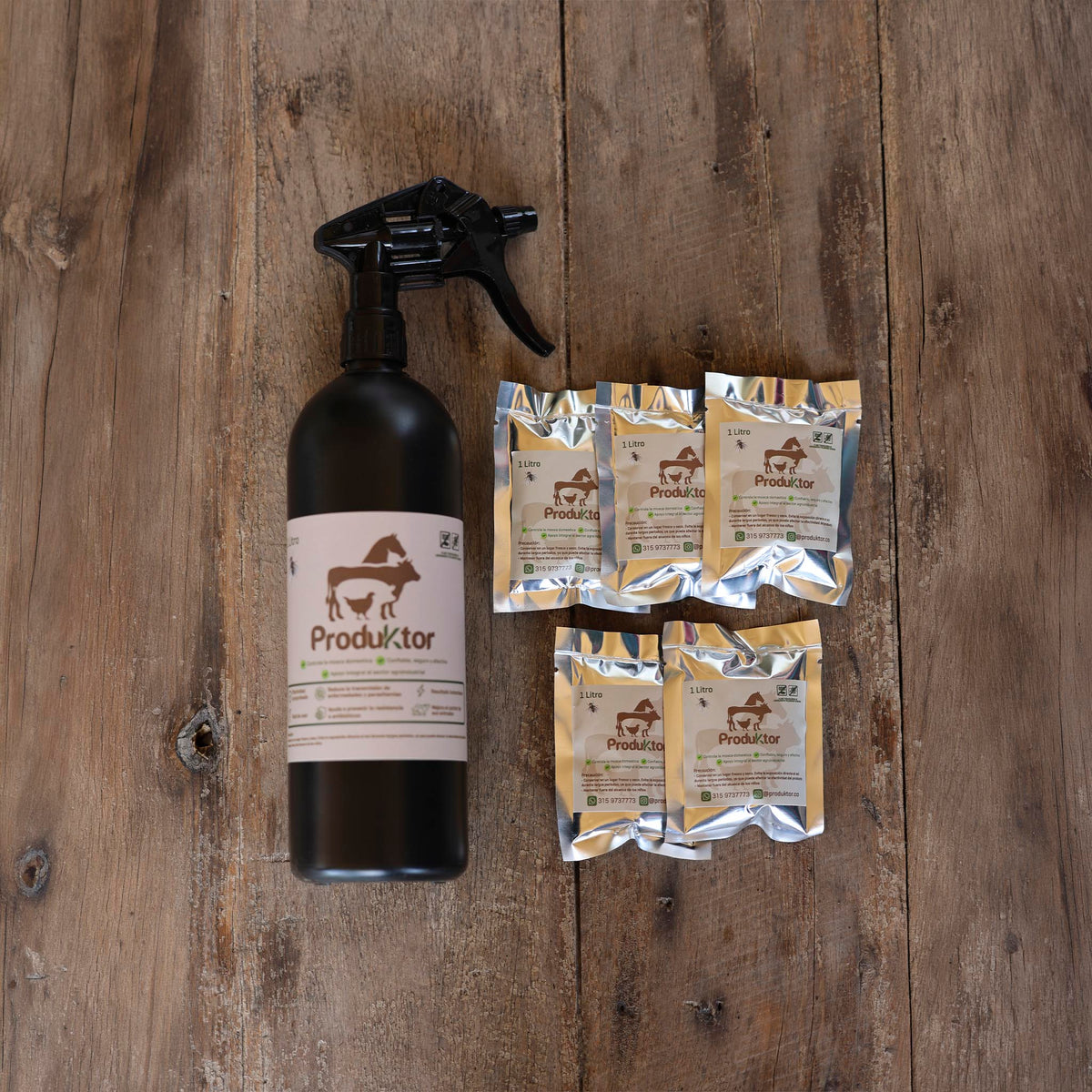 Kit ProduKtor de 5 litros: atomizador ámbar y cinco sobres de cebo para moscas sobre una mesa de madera.