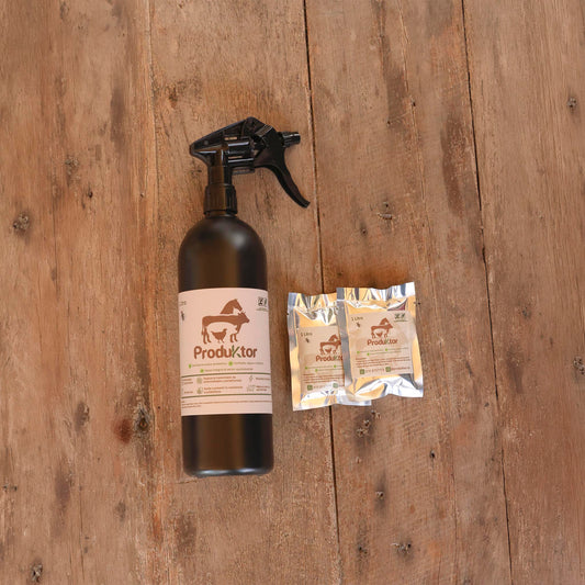 Kit ProduKtor de 2 litros: atomizador ámbar y dos sobres de cebo para moscas sobre una mesa de madera.